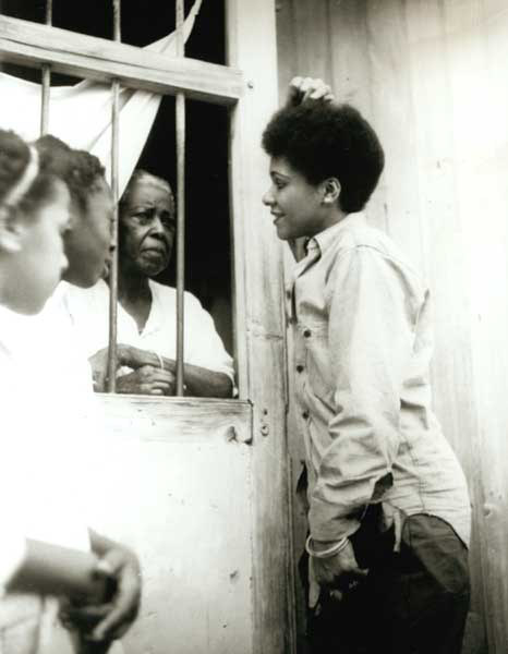 Katherine Dunham talking with women through window gate in Cuba, 1946–1947.